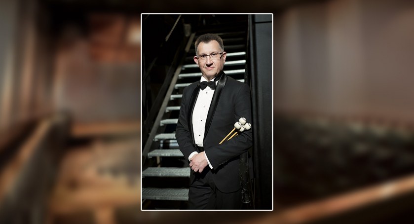 Adam Mieczykowski na tle wizualizacji sali koncertowej w nowej, stałej siedzibie POS