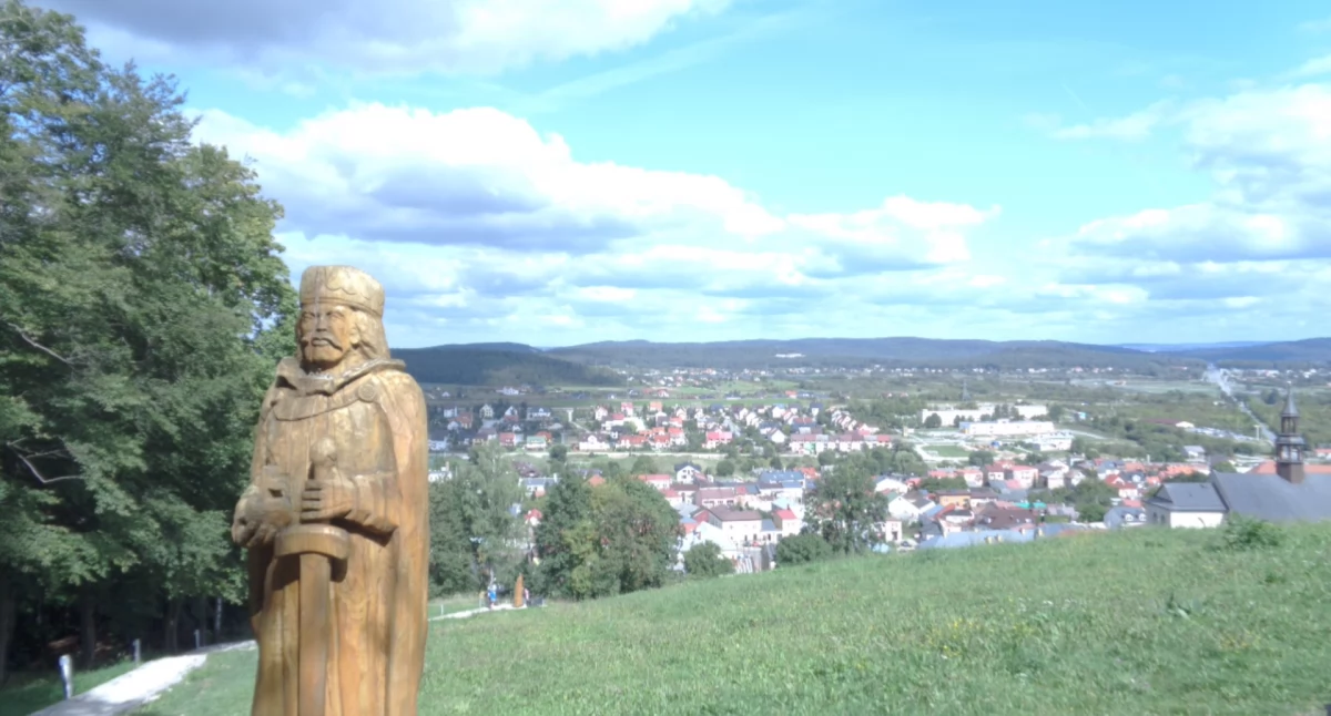 Drewniana figura króla Kazimierza Jagiellończyka obok murów zamku w Chęcinach. Widok z zamku na miasto